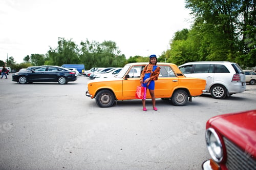 Preview: African american lady near orange classic retro car