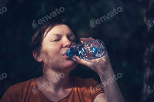 Preview: Woman drinking water outdoors