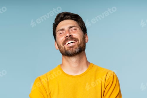 Preview: Happy bearded man model posing with closed eyes isolated on blue background