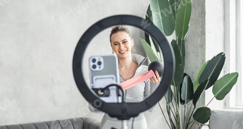 Preview: Young sporty slim woman yoga coach, female fitness instructor records video of online yoga training.