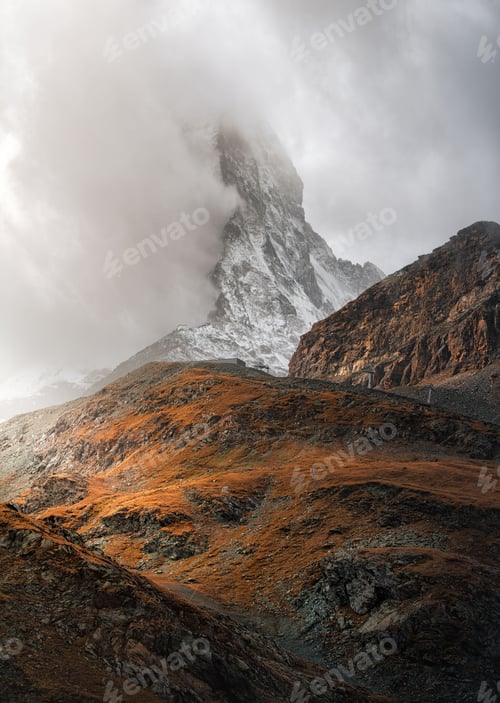 Preview: Vertical shot of a mountain peak hidden behind fog