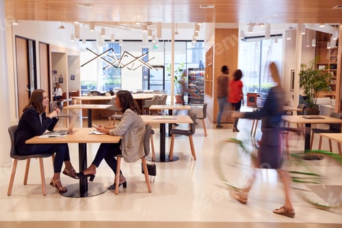 Preview: Interior Of Modern Open Plan Office With People Working And Commuters Arriving On Bikes