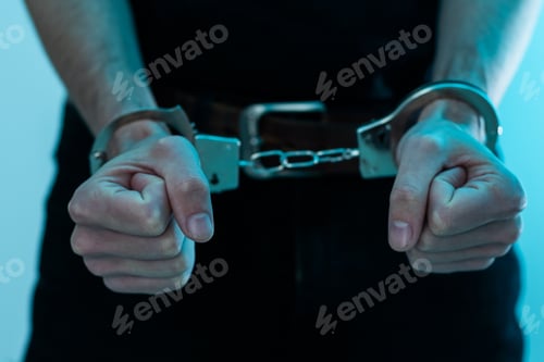 Preview: Young man desperate to catch the iron prison,prisoner concept,Handcuffed hands of a prisoner in