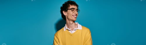 Preview: Stylish young man showcases modern fashion against a vibrant blue backdrop