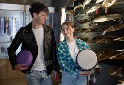Vista previa: A man and woman hold a tambourine and purple ball in a store