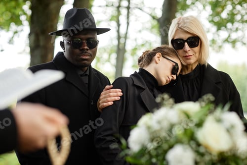 Preview: Mother and daughter embracing at outdoor funeral