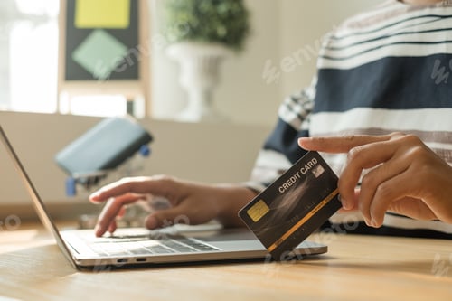 Preview: The businesswoman's hand is holding a credit card and using a laptop for online shopping and interne