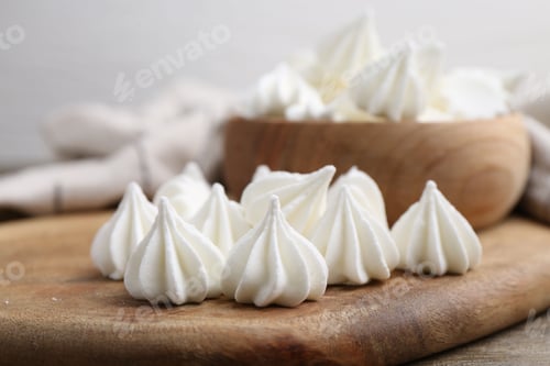 Preview: Delicious meringue cookies on wooden table, closeup