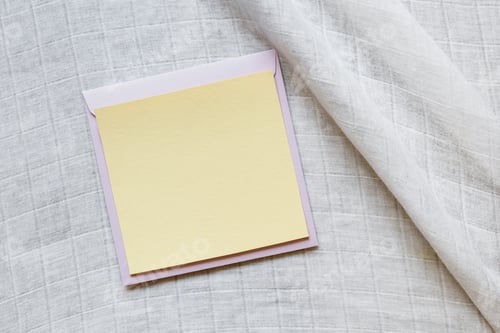 Preview: Blank greeting card mockup. Beige empty sheet of paper mockup on envelope on white linen background.