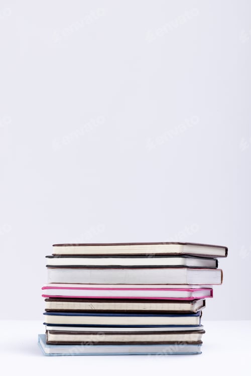 Preview: Close up of stack of books and notebooks with copy space on white background