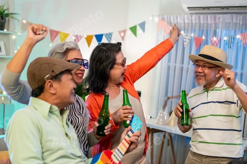Visualização: Grupo de amigo sênior asiático fazendo festa noturna na sala de estar em casa.