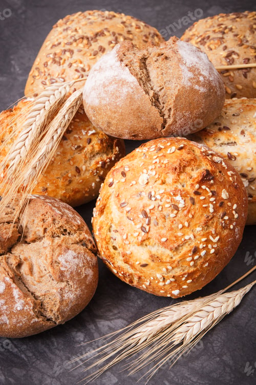 Preview: Fresh baked rolls with seeds and ears of rye or wheat grain