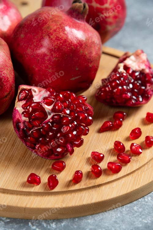Preview: Sliced ripe pomegranate on a wooden board