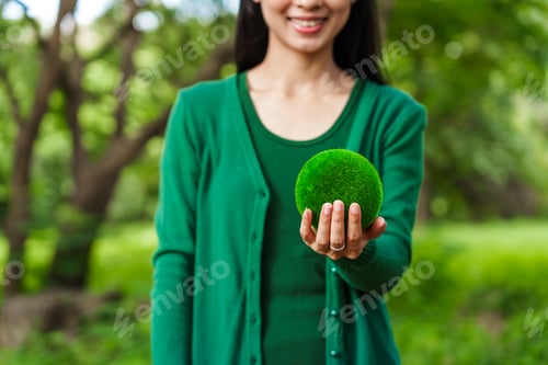Preview: Forest conservationist holds small globe in hands,symbolizing global responsibility for protecting