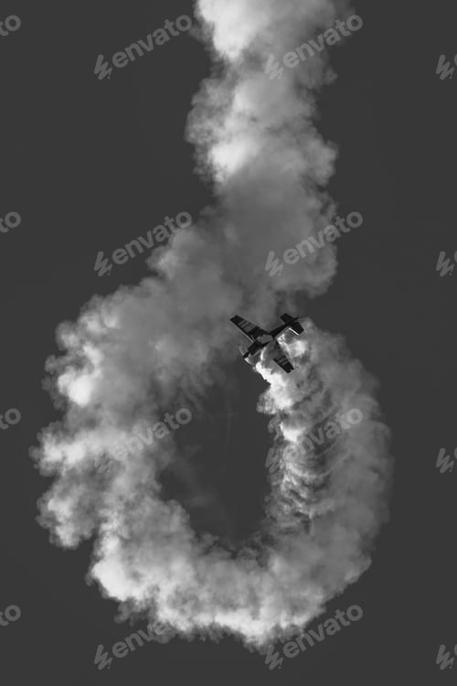 Preview: Aerobatic airplane with smoke trail in black and white.