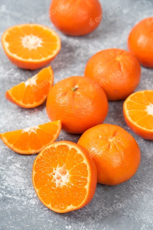 Preview: Whole and slice juicy fresh orange fruits placed on a stone background