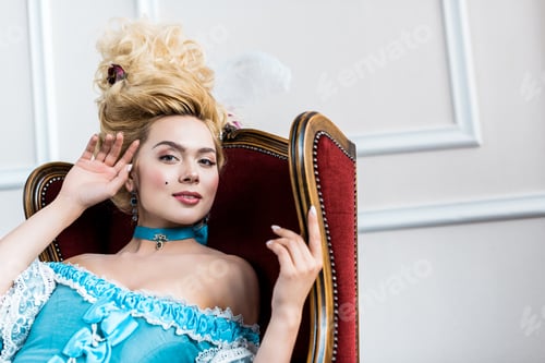 Preview: cheerful victorian woman in blue dress sitting on antique chair