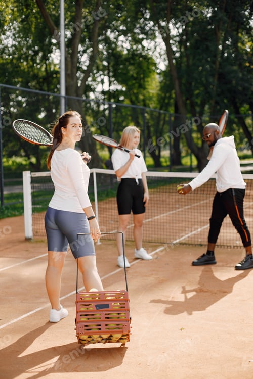 Preview: Two women and black race trainer at tennis court