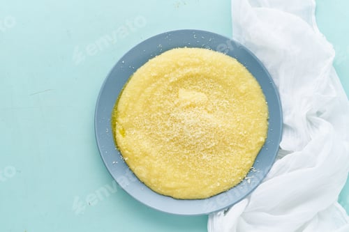 Preview: Urkainian polenta porridge on pastel turquoise aquamarine background top view copy space