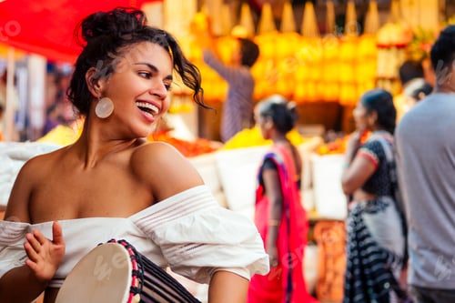 Preview: indian wearing fashionable clothes posing in asian bazar playing djembe music drummer