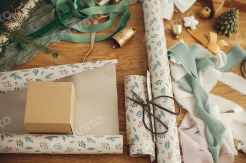 Preview: Wrapping christmas gift. Stylish festive wrapping paper, craft gift box, ribbonson wooden table
