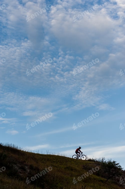 Preview: Silhouette of a cross country cyclist going downhill