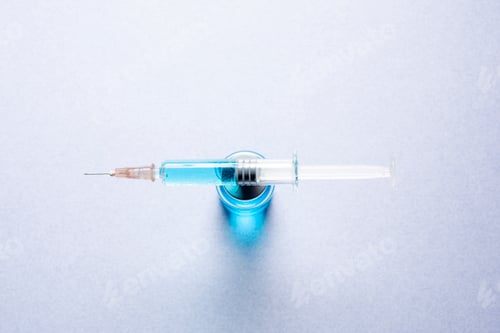Preview: Closeup shot of a jar and a syringe filled with blue liquid