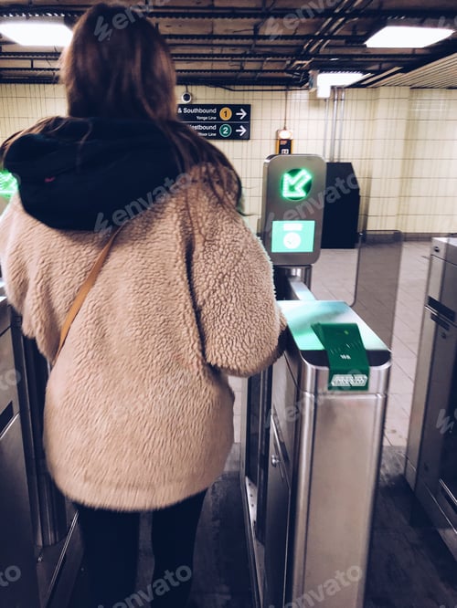 Preview: Young girl is paying the transportation fare to go trough the gates into the underground subway