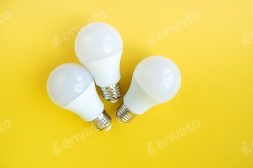 Preview: Three LED light bulbs on yellow background. energy saving concept.