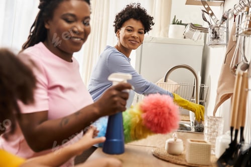 Preview: Loving family bonding while cleaning together at home in the kitchen