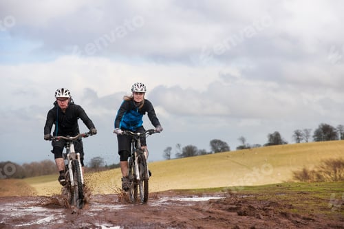 Preview: Couple riding bike through muddy puddles