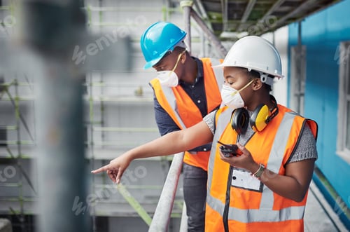 Preview: Shot of a young woman using a walkie talkie while working with her colleague at a construction site