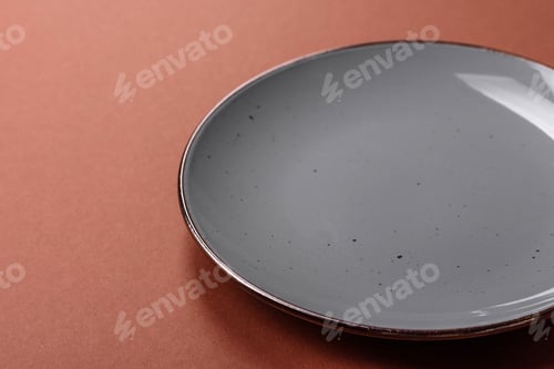 Preview: Empty ceramic plate on a monochrome brown background