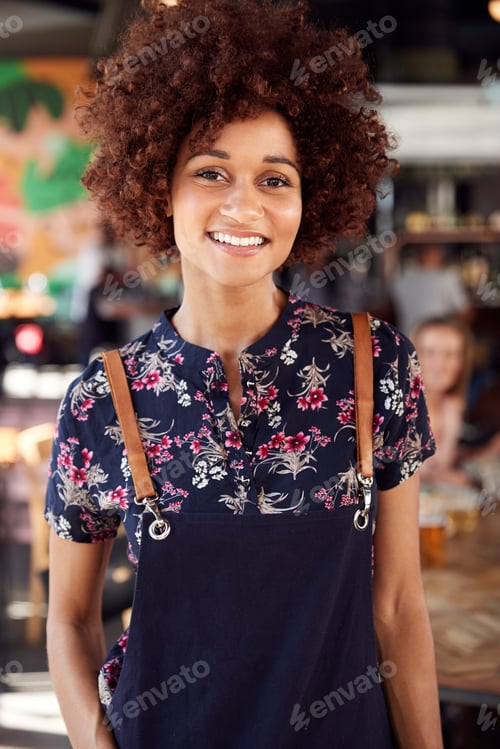 Preview: Portrait Of Waitress Serving In Busy Bar Restaurant