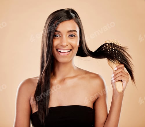 Preview: Portrait, beauty and a woman brushing her hair in studio on a cream background for natural or luxur