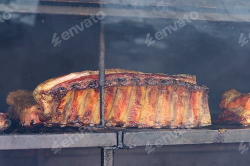 Preview: Chef cooking fresh pork ribs on the charcoal grill, during food festival