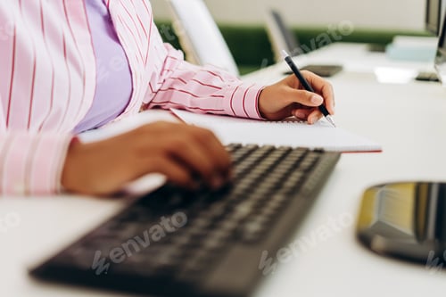 Preview: Office worker taking notes while using computer keyboard copywriter typing, selective focus on hands