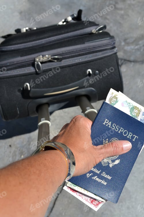 Preview: Woman holding passport and cash while pulling suitcase or luggage through airport on adventure trip