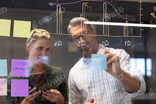 Preview: Caucasian colleagues seen through glass wall planning strategy together in meeting room