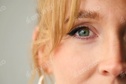 Preview: Close Up Studio Shot Of Woman's Eye Looking At Camera Against Plain Studio Background