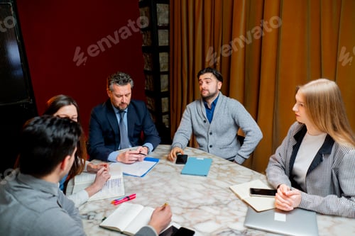 Preview: office workers are sitting at the head of the director discussing a business plan