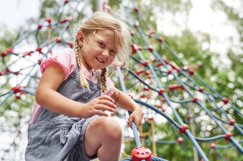 Preview: Caucasian little girl playing at playground in summer day