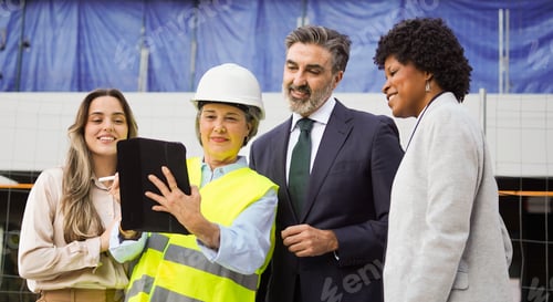 Preview: Multi-ethnic team of construction managers using tablet at building site