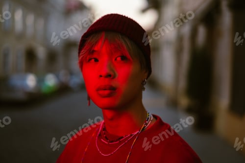 Preview: Asian boy wearing hat looking aside while standing on street
