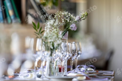 Preview: Closeup of a festive table with white dishes and glasses, blurred background