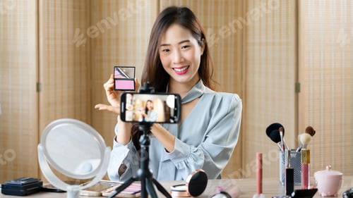Preview: Beauty blogger reviewing blush on product while recording video on smartphone for makeup vlogger
