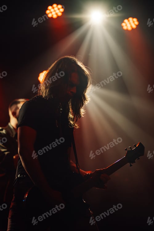 Preview: Guitarist performing live on stage under warm lights