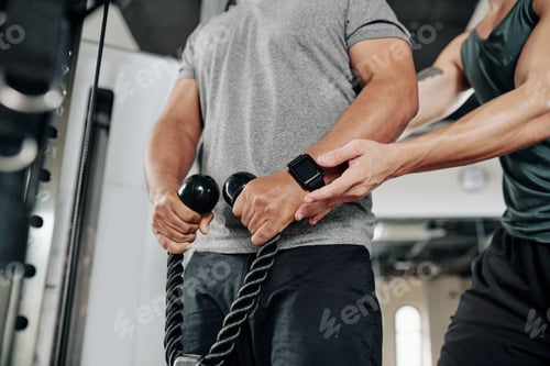 Preview: Man Working Out Assisted by Trainer at Gym