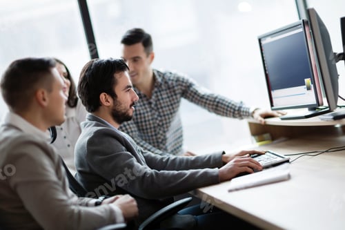 Preview: Young businesspeople working on computer in office