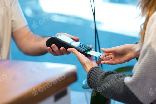 Preview: Woman using credit card to pay for beauty treatment at spa reception